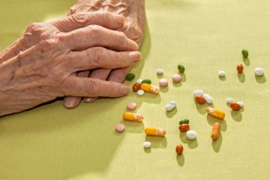 Hands of an elderly lady with medication.